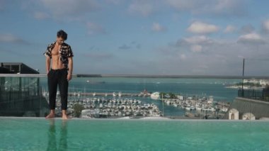 Marinanın arka planında yürüyen bir adam.