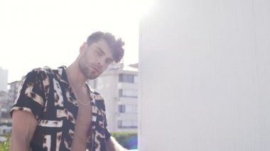 Sokakta poz veren günlük kıyafetli adam.