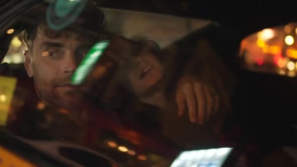 Мужчина обнимает девушку на заднем сидении машины — стоковое видео
