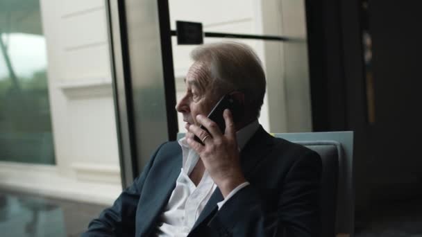 Uomo d'affari parlando seriamente su un telefono cellulare — Video Stock