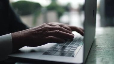 Dizüstü bilgisayarda yazan yaşlı bir adam