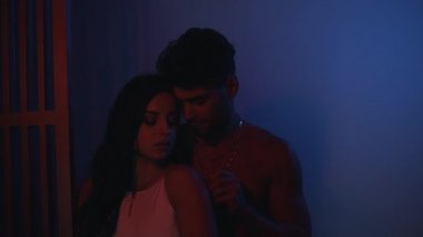 Kadın ve erkek neon ışıkta güneşleniyor.