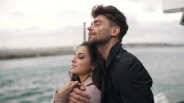 Adam bulutlu bir havada yatta bir kıza sarılıyor.
