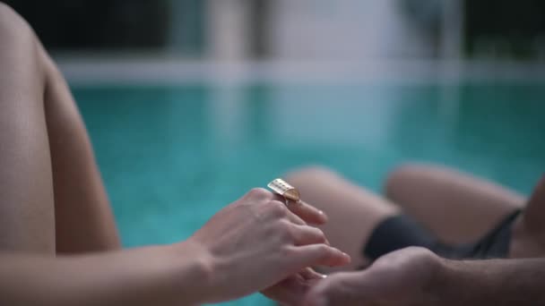 Seorang pria dengan seorang gadis berpegangan tangan dengan kolam renang — Stok Video
