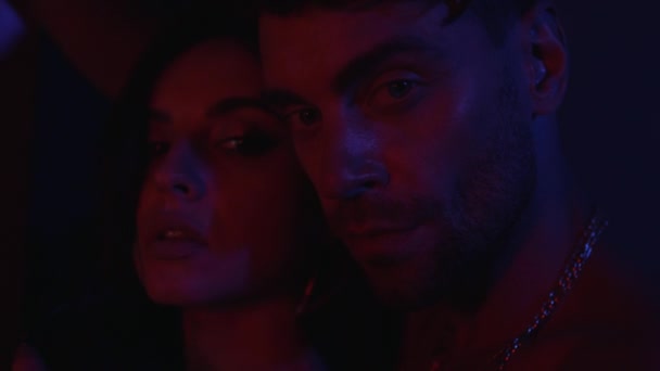 Muž a žena tváří v tvář v neonovém světle — Stock video
