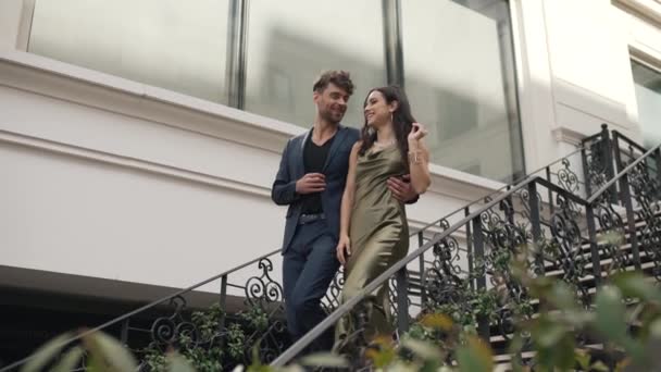 Lyckliga par går ner för trapporna — Stockvideo