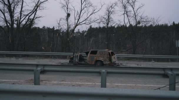 Burnt civilian car on the road Stock Video