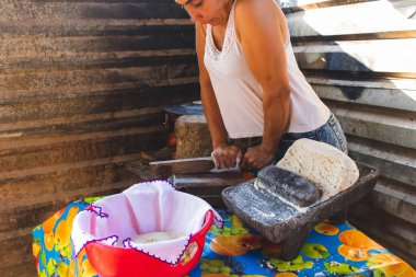 Meksikalı bir kadın, cuautla, jalisco, mex 'te ev yapımı tortilla yapmak için soba ve odun sobasında mısırlara işkence ediyor.
