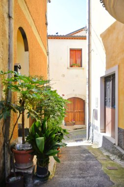 İtalya 'nın Salerno eyaletindeki bir ortaçağ köyü olan Teggiano' nun eski evleri arasında dar bir sokak..