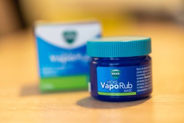 Bir kutu içinde Vicks VapoRub cilt kremi ve masada kavanoz.