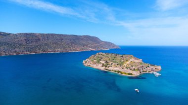 Yunanistan 'daki Spinalonga kalesinin mavi sularda mavi bulutlu gökyüzünün altında bir hava manzarası