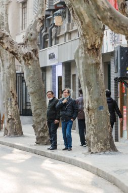Çin 'in Şangay caddesinde hayatlarına devam eden insanların dikey görüntüsü.