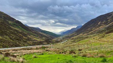 Gündüz vakti sisli bulutların altında dağlık bir arazide büyüleyici bir manzara.