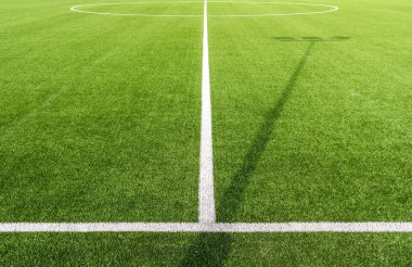 Beyaz çizgileri ve suni çimleri olan bir futbol sahasının yakın çekimi.