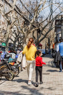 Çin, Şangay sokaklarında yürüyen insanların dikey bir arka görüntüsü.