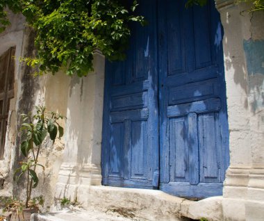 Yeşil yapraklı eski mavi ahşap kapılar. Oluştur, Yunanistan.