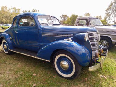 Eski mavi Chevrolet Chevy Master iş coupe 1938 by GM. Yeşil, doğa, çimen, ağaçlar. Klasik araba şovu. Kopyalama alanı