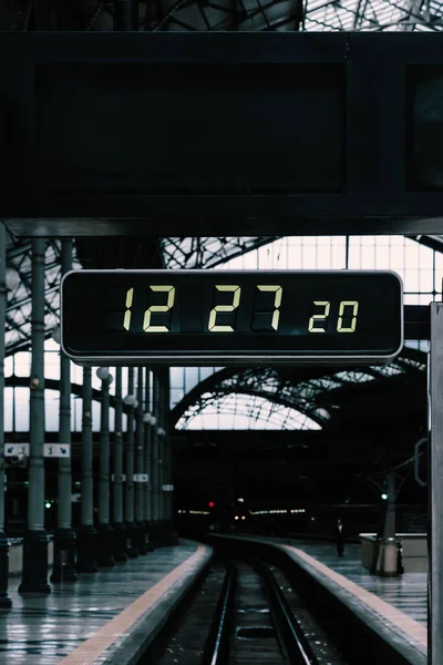 A digital clock above the railway in a train station