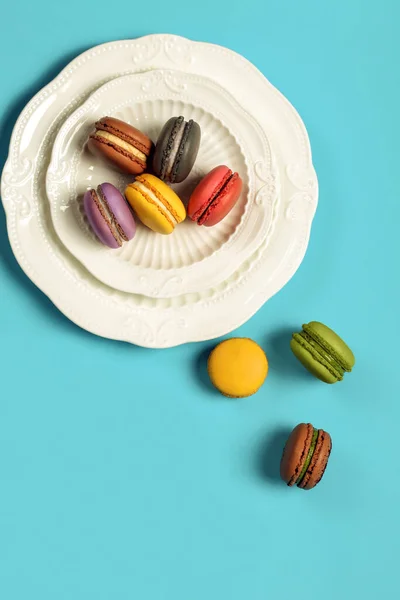 Top View Plate Colorful Macarons Blue Table Some Scattered — Stock Photo, Image