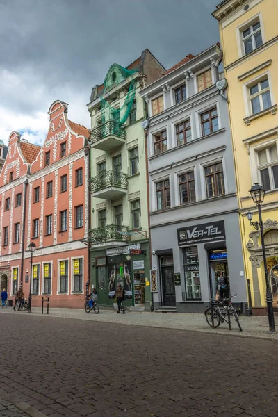在波兰托伦的传统建筑下 人们走在商店前面的垂直镜头 — 图库照片