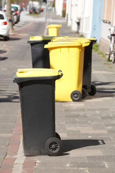 Tiro Vertical Latas Lixo Amarelo Preto Uma Rua Dia Ensolarado — Fotografia de Stock