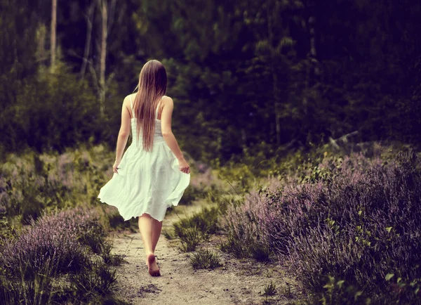 Baksidan Kvinnlig Vit Klänning Promenader Gångväg Omgiven Blommande Träd Skogen — Stockfoto