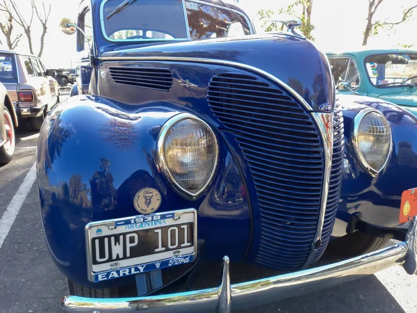 vintage blue 1938 Ford V8 85 De Luxe two door coupe in a park. Front view. Grille. Nature, trees. Classic car show.