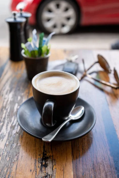 Açık Kafedeki Ahşap Masada Bir Fincan Kahvenin Dikey Yakın Çekimi — Stok fotoğraf