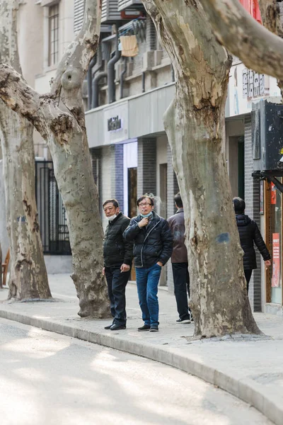 Çin 'in Şangay caddesinde hayatlarına devam eden insanların dikey görüntüsü.