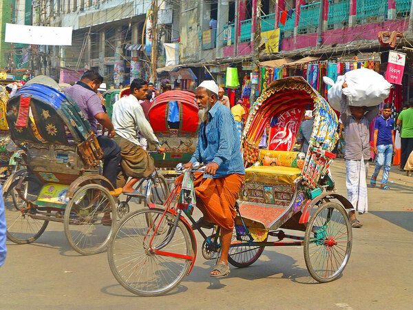 Colorful bicycle rickshaws in the busy streets of Dhaka in Bangladesh, transporting goods and people
