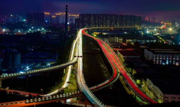 A high angle shot of lighted highways and infrastructure in Shanghai with buildings in the background