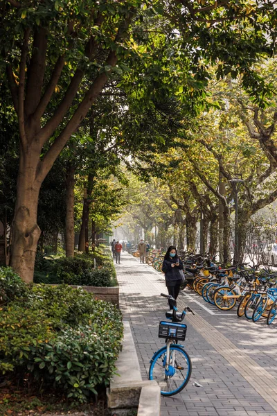 中国の駐車自転車や木のある公園の通路を歩く人々の垂直ショット — ストック写真