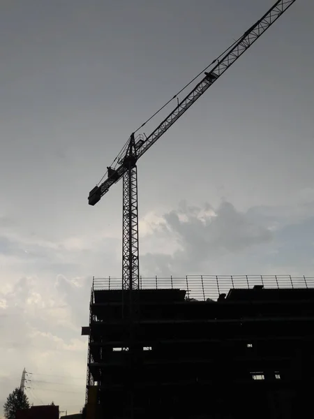 建設現場でのタワークレーンのシルエットの垂直ショット — ストック写真