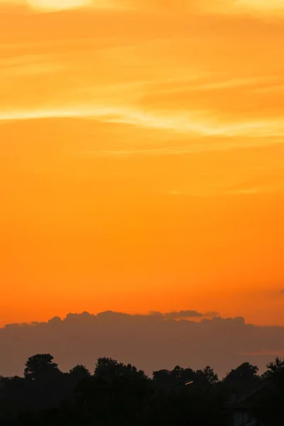Eine Vertikale Aufnahme Des Orangen Sonnenuntergangs Über Den Silhouetten Der — Stockfoto