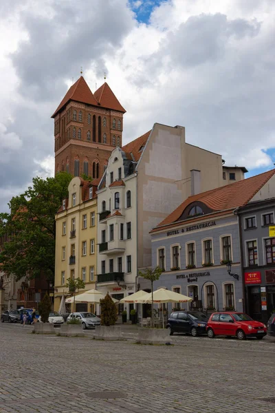 Zdjęcie Pionowe Samochodów Zaparkowanych Przed Sklepami Pod Tradycyjnymi Budynkami Toruniu — Zdjęcie stockowe