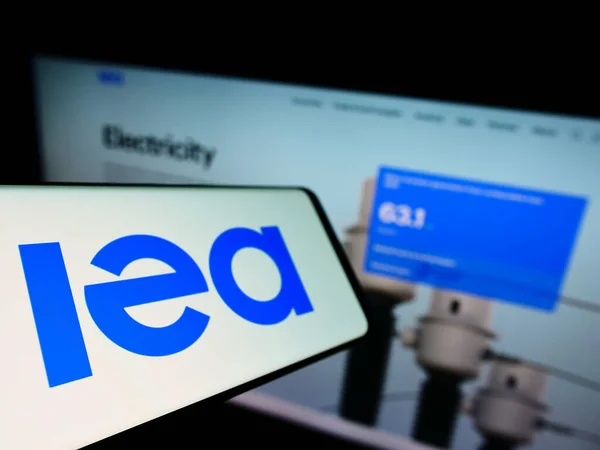 Uluslararası Enerji Ajansı 'nın (IEA) logosuna sahip akıllı telefon iş sitesinin önünde ekranda. Telefon ekranının soluna odaklan.