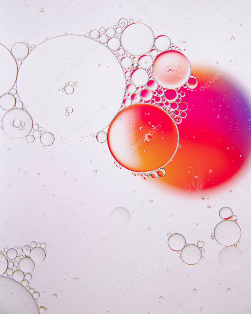 An abstract background of colorful large and small oil circles on the water