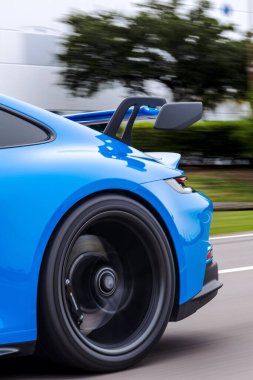 Modern mavi bir Porsche 911 GT3 spor arabasının arka tekerleğinin dikey çekimi