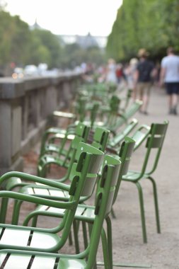 Paris 'teki Tuilleries Sarayı' nın yakınındaki köprüde bir sıra yeşil metal sandalyenin dikey çekimi.