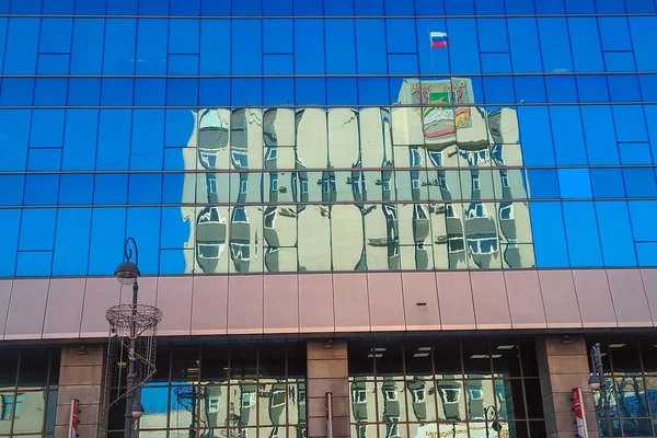 Vladivostok\'s mayor office seen through reflection on a glass wall of the building across the road