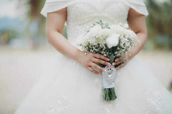 新娘穿着漂亮的长裙牵着她的花束 — 图库照片