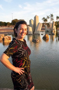 Güneşli bir günde parkta olgun bir bayan arka planda kristallerle eğleniyor.