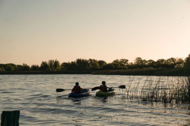 Doğada bir gölde kayak yapan insanların güzel bir fotoğrafı.