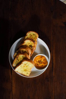 Kahvaltı için soslu sarımsaklı ekmeğin dikey çekimi.