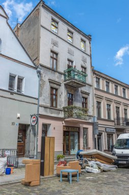 Bir apartmanın önündeki kaldırımda dikey bir mobilya görüntüsü.