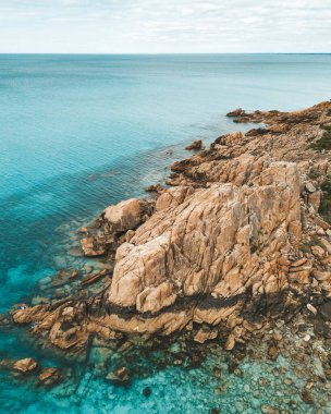 Kayalık kayalıkların ve berrak deniz suyunun dikey görüntüsü
