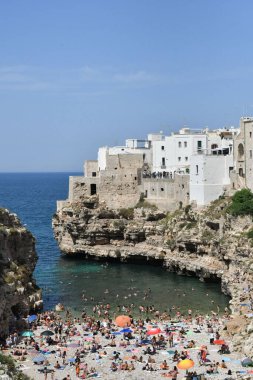Adriyatik Denizi 'nin uçurumunda bulunan ortaçağ köyünün küçük plajındaki turistler.
