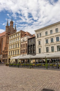 Polonya 'nın renkli binaları ve kafeleri olan Torun' daki tarihi Eski Şehir 'in ana meydanının dikey görüntüsü.