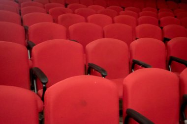 Tiyatroda boş kırmızı sandalyeler. Fotoğraf el feneri kullanılarak çekildi.