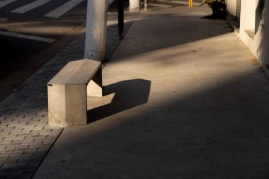 Güneşin altında çimento sokak bankının güzel bir görüntüsü.